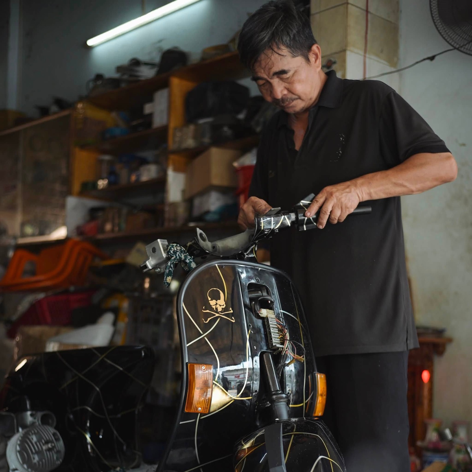 Chú Quý Bảy Hổ sửa Vespa đen trong xưởng